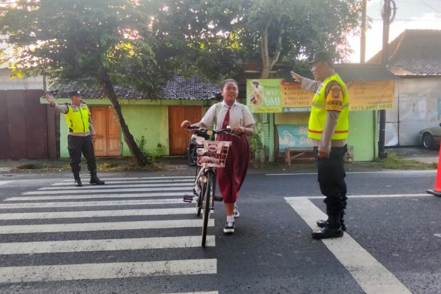 Prioritas Keselamatan Siswa, Personel Polsek Wungu Seberangkan Anak Sekolah di SDN 01 Munggut Senin Pagi